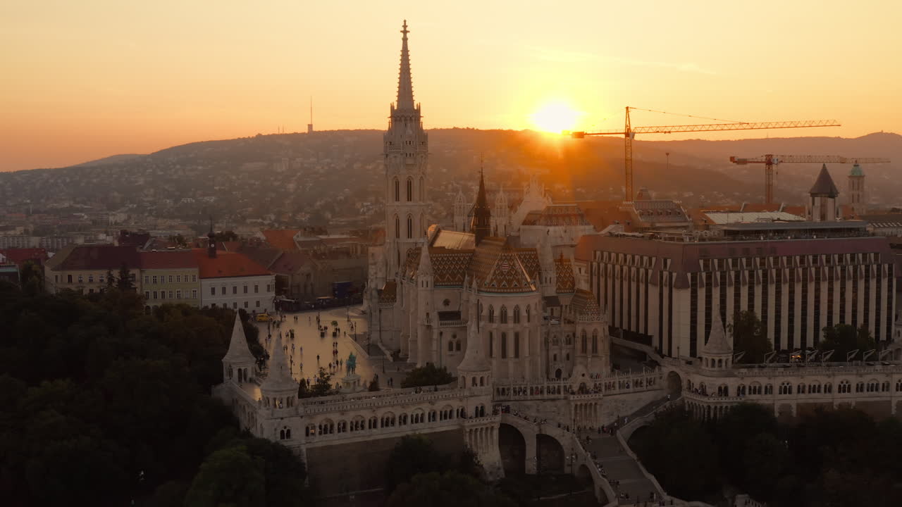 vista panorámica de la iglesia de matías con la puesta de sol detrás de las colinas de buda