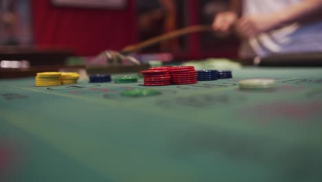 un crupier está manejando las fichas en una mesa de ruleta con su rastrillo mientras la rueda gira-2