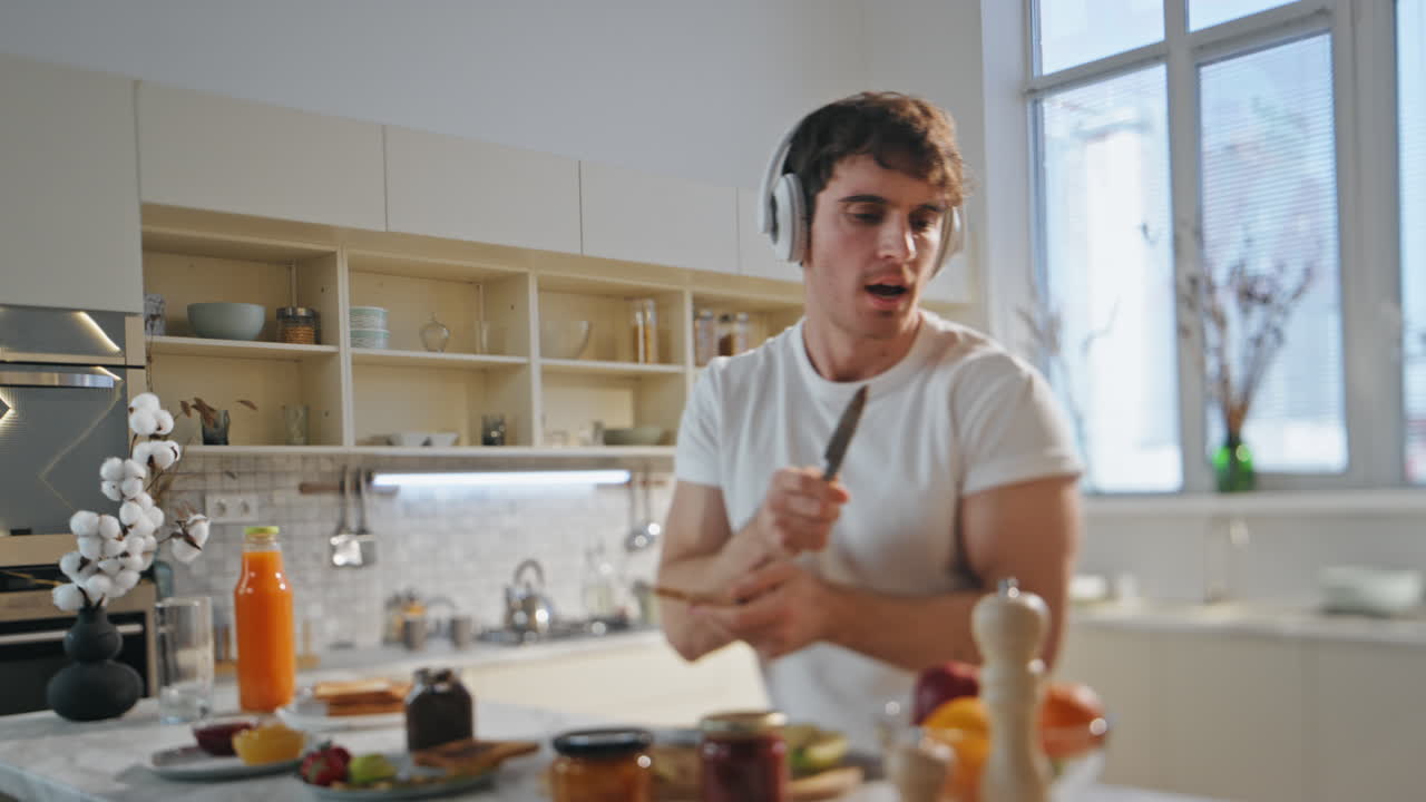hombre cocinando comida auriculares divertido bailando cocina de cerca. hombre escuchando música