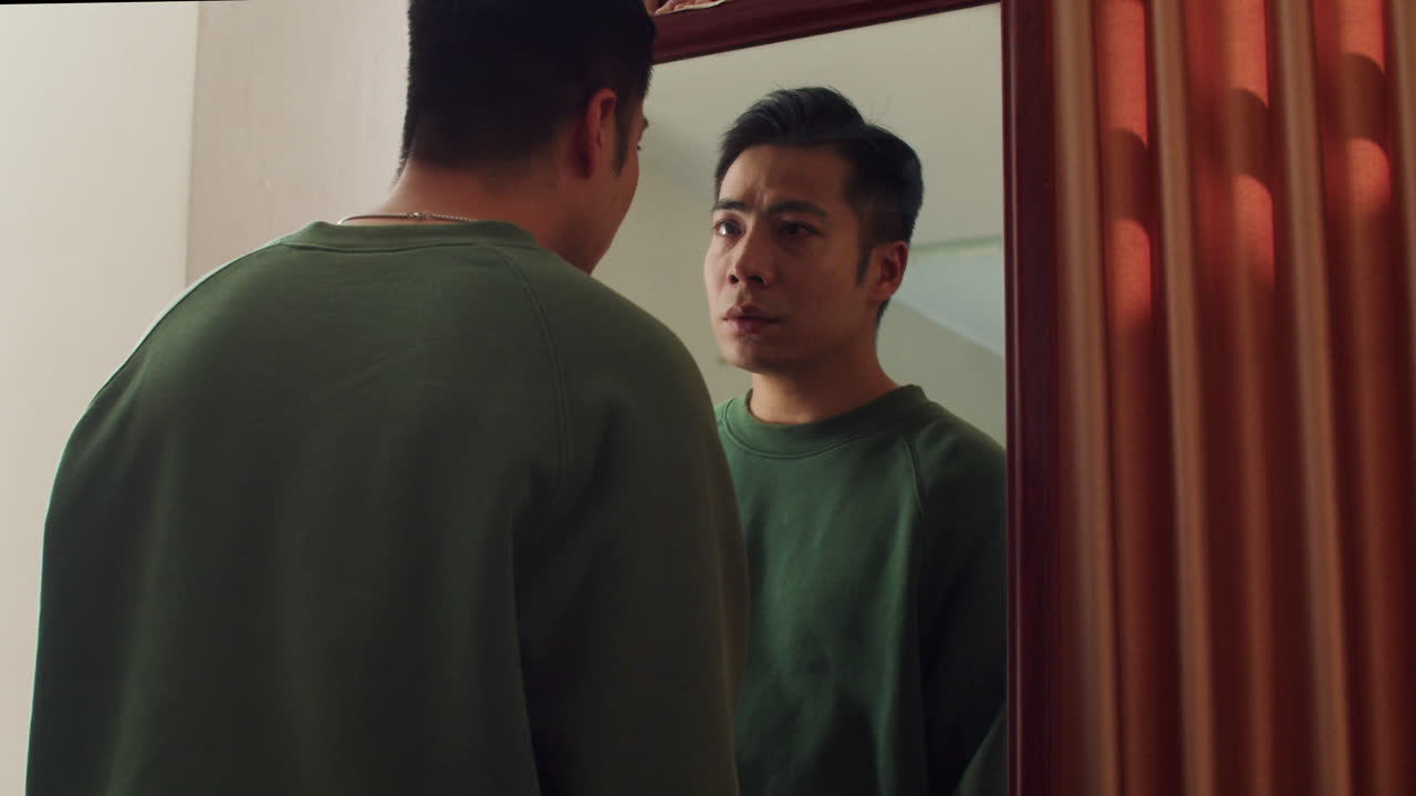 Man looking his reflection in a mirror