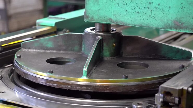 Secured on a rotary table, drum lids undergo a precise, automated machining process