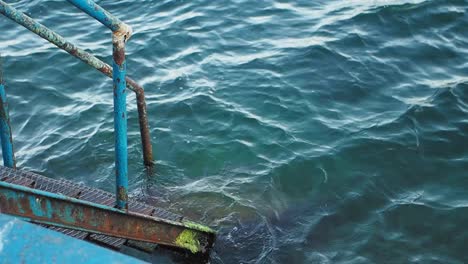 rusty metal stairs leading into the ocean water