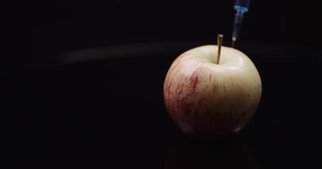 Food-Genetic-Modification-Syringle-Injecting-Liqquid-In-Apple-Gmo-Modification-Concept-