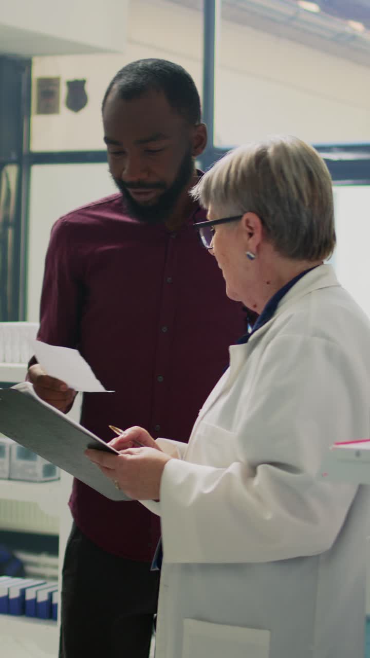 Vertical video: Young male customer giving prescription paper to assistant