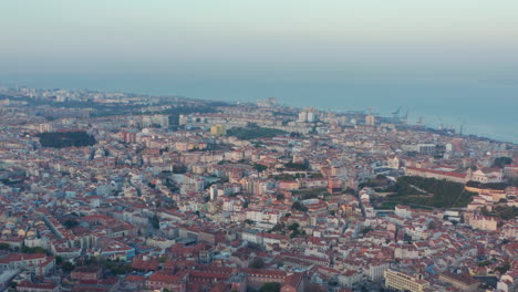 Wide-aerial-view-of-rooftops-of-coastal-residential-colorful-houses-in-downtown-city-center-of-Lisbon,-Portugal