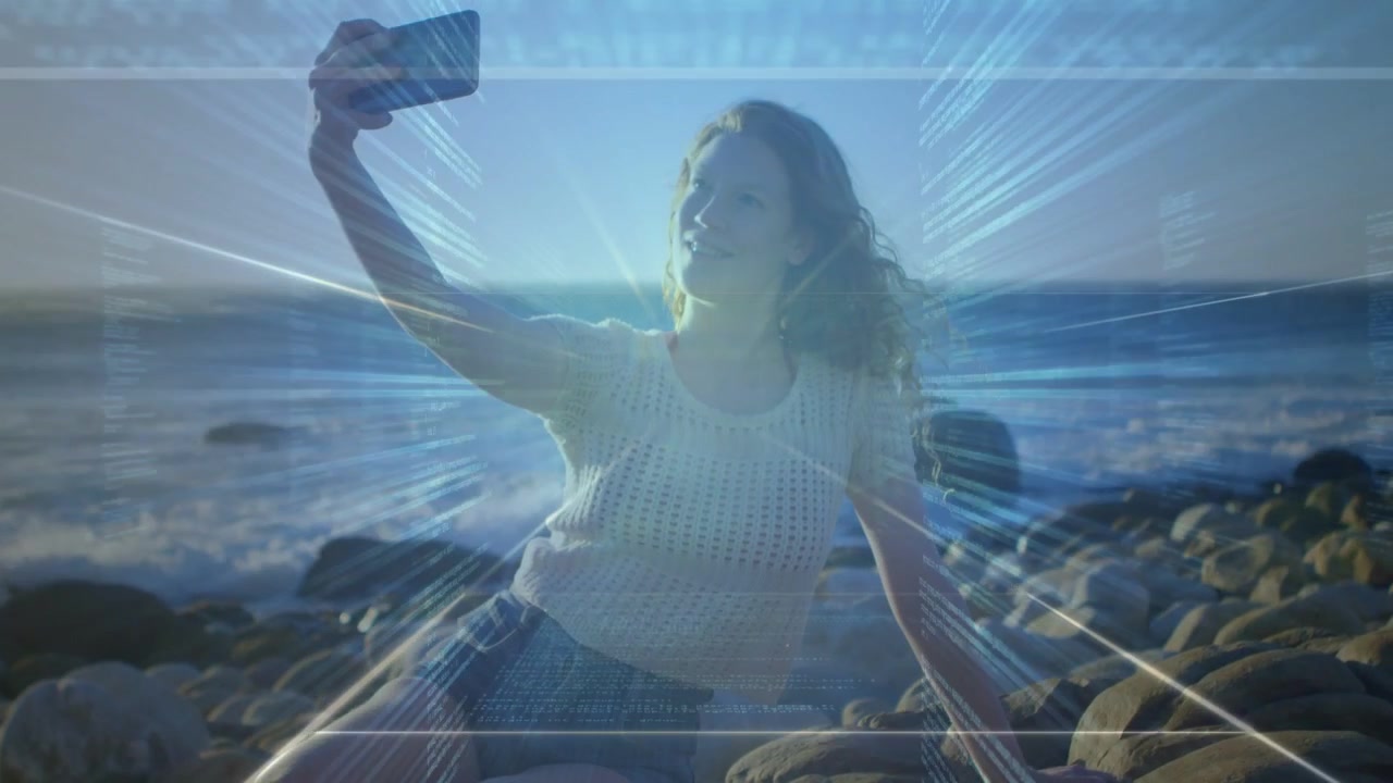 Donna in posa sulle rocce che solleva il telefono mentre controlla lo schermo, con glitch che si amplificano per i social media.