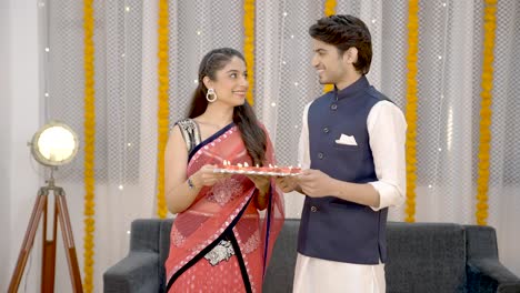 pareja india sosteniendo a diye en diwali