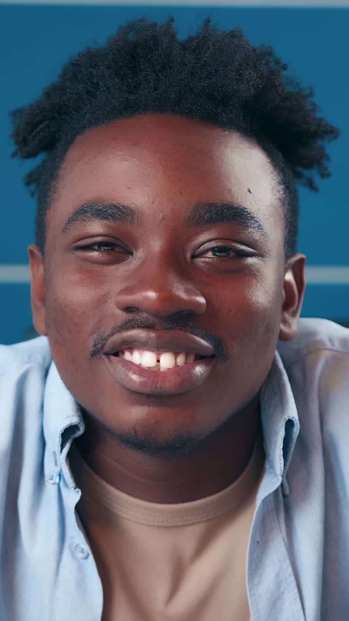 Joyful young man smiles brightly in a vibrant indoor space showcasing confidence