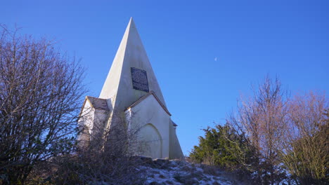 Wide-shot-of-Farley-Mount-monument-UK-in-winter-heavy-frost-moon-in-day-sky-4K