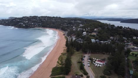 Aerial-view-of-a-small-seaside-town-on-a-peninsula-and-a-sandy-beach