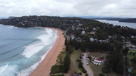 vista aérea de una pequeña ciudad costera en una península y una playa de arena