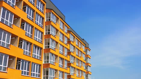 block of flats with large balconies. facade of a new high rise building on blue sky backdrop. bright architecture in the city. modern multi storey house.