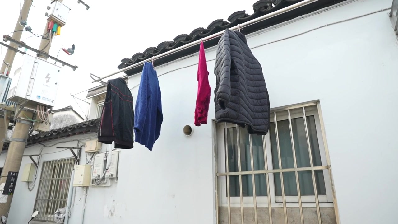 Wet clothes hanging to dry on a clothesline in an alleyway in a traditional Chinese city
