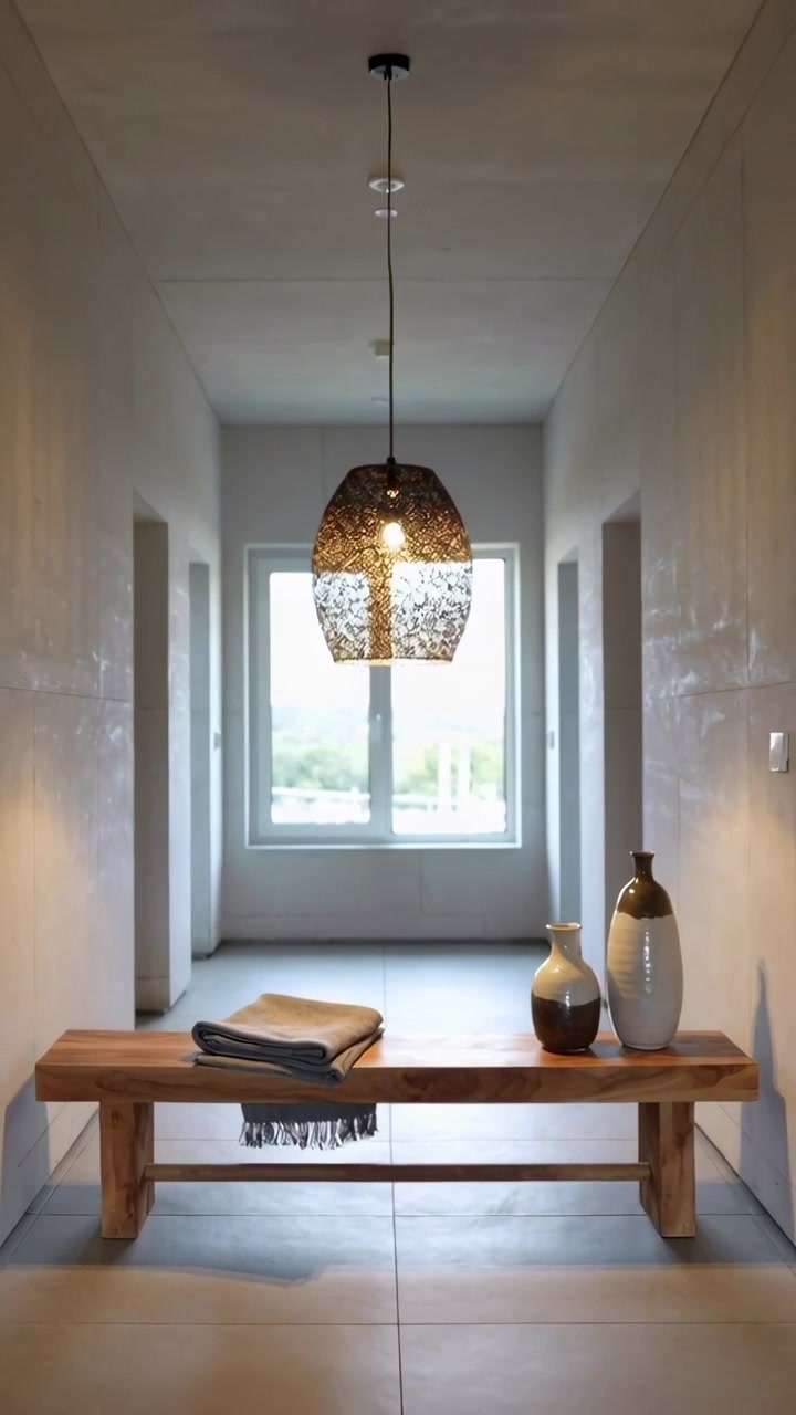 Video verticale: Luce diurna che cambia dalla finestra proietta un bagliore nell'ingresso di casa, illuminando panca, lampada, vasi