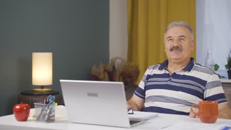 home office worker old man looking emotional at camera.