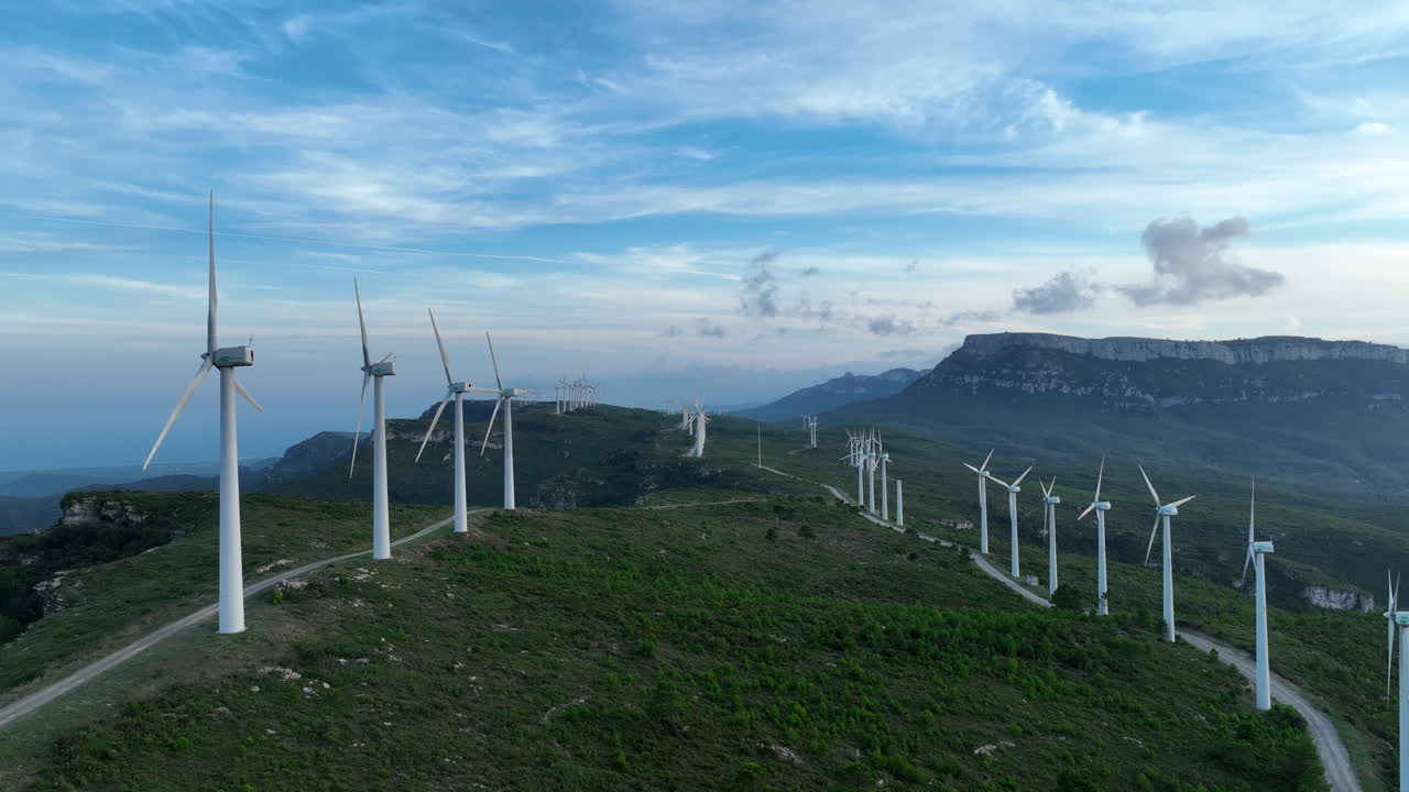 산이 있는 슬로우 모션의 풍력 발전소