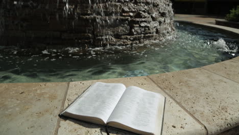 Heiliges-Buch-Vor-Einem-Friedlichen-Wasserbrunnen-Hintergrund:-Dolly-Up