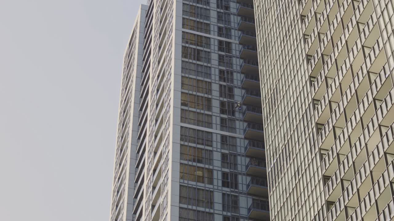 trabajador limpiando la ventana del edificio - ángulo bajo