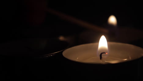 a group of candles being lit with a match one by one