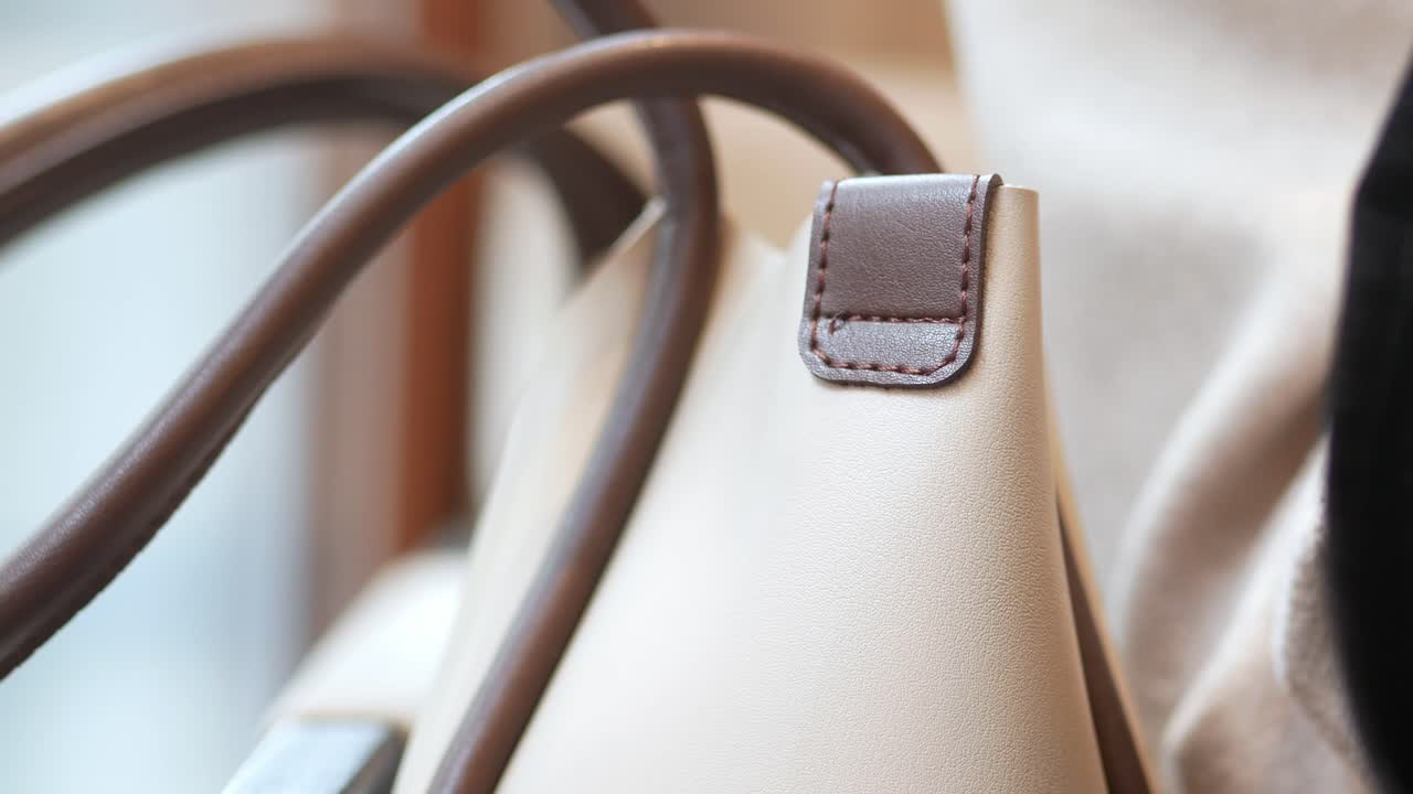 Primo piano del manico di una borsa in pelle beige