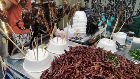 タイのチャイナタウンで料理された昆虫を売っているストリートフードの売り手