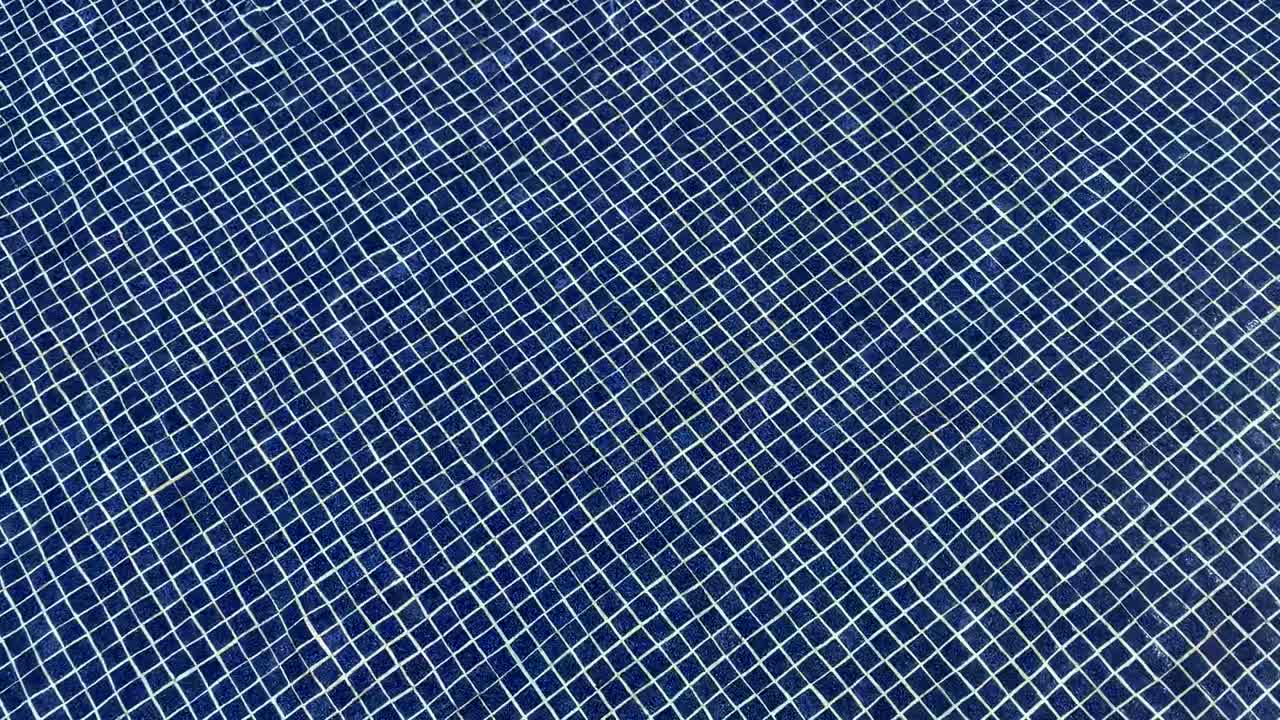 A relaxing image of water moving over a mosaic blue tile background