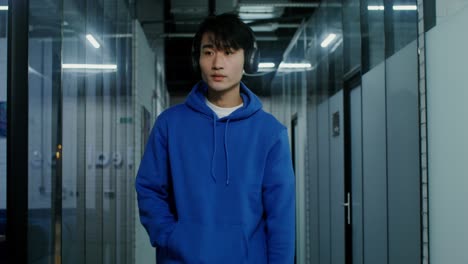 man walking in an office corridor with headphones