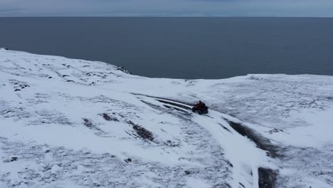 aventurero en quad llegando a la costa de njarðvík durante el invierno, antena