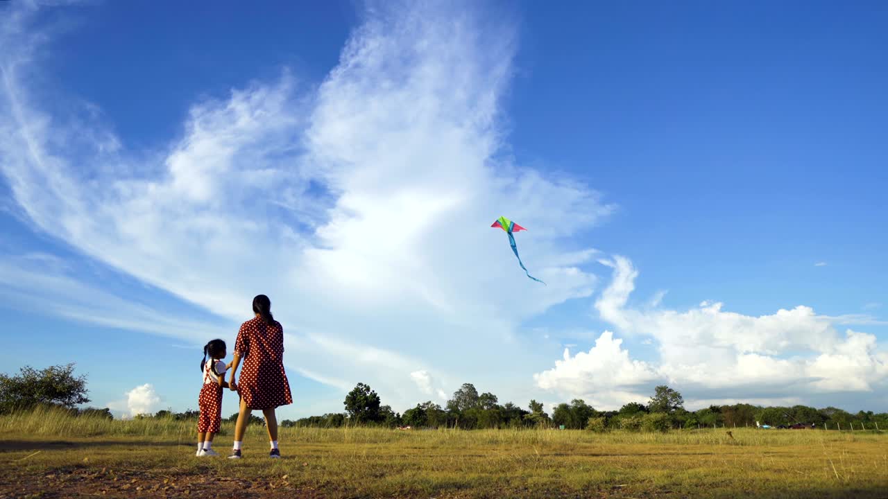 familias asiáticas, madres e hijas están jugando a las cometas en una feliz fiesta.