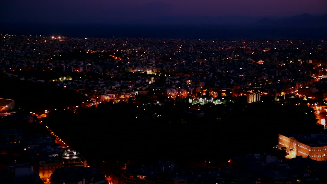 황혼이나 밤에 아테네 그리스와 아크로폴리스의 아름다운 패닝 샷