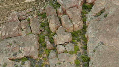 drone flies in bird's eye view over desert landscape and rock formations in cederberg wilderness area in south africa over an empty road in the desert - drone turns slightly upwards