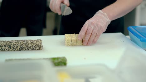 cook cuts a japanese roll with white sesame