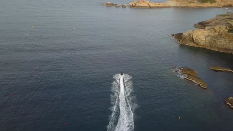 Aerial-shot-following-a-jet-ski-in-the-Costa-Brava,-Catalonia