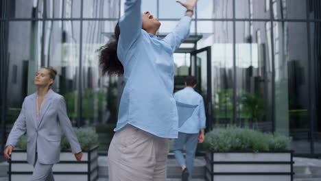 happy corporate worker laughing dancing around in crowded contemporary street.