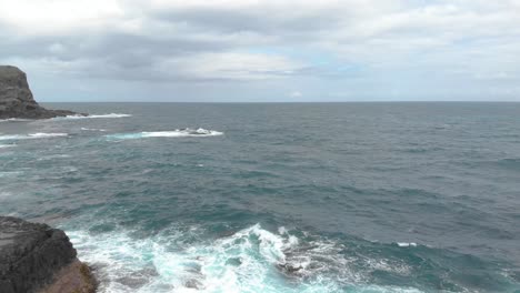 toma aérea en movimiento hacia adelante sobre océanos salvajes por las rocas y acantilados de la península de mornington victoria