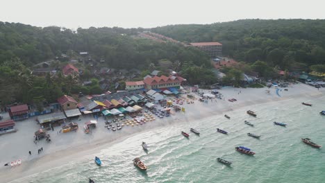 Aerial-view-of-long-beach-with-boats-moored-in-perhentian-islands,-malaysia,-showing-the-beauty-of-this-tropical-paradise