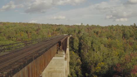 flying beside a rusty railroad trestle during an early fall golden hour aerial