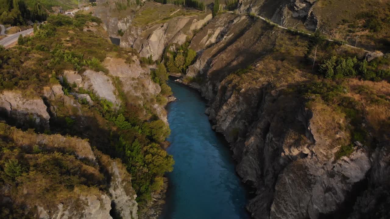 Luftfoto over elven i en steinete canyon som vipper opp mot Kongenes Pilarer, Ringenes Herre