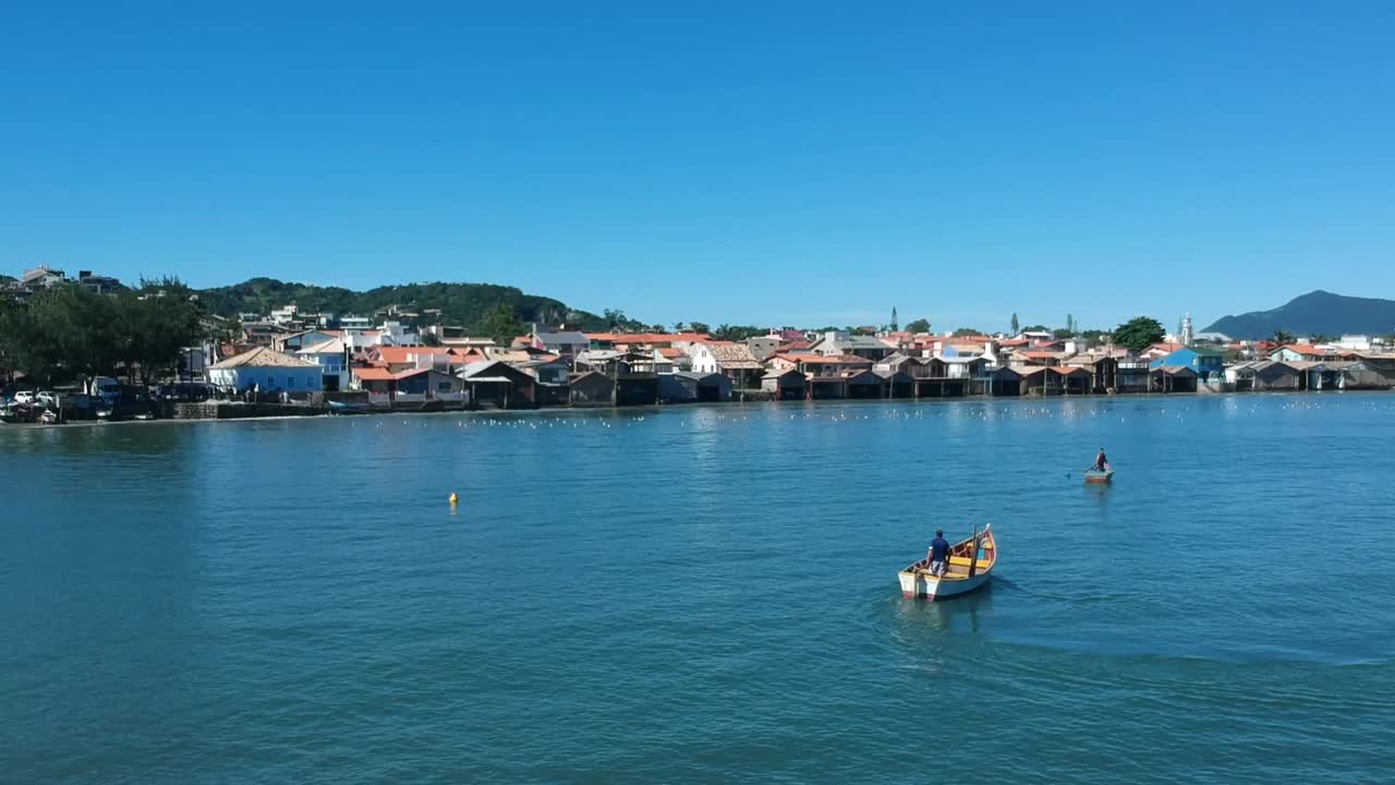 siguiendo a un pescador por la mañana, en su barco de pesca, en la costa de brasil