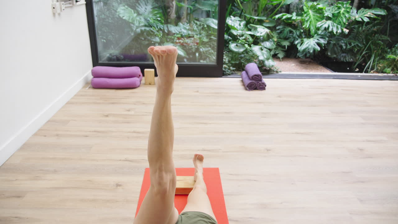 Frau praktiziert die Beine-an-der-Wand-Yoga-Pose im Studio
