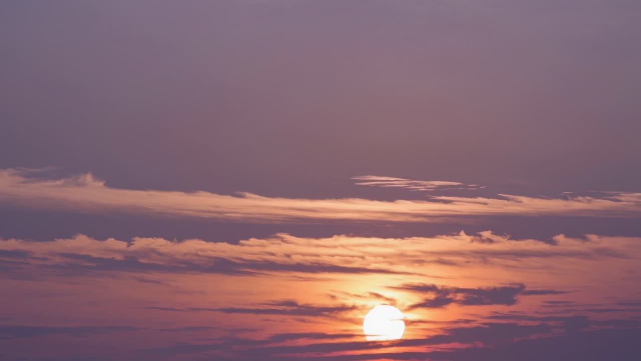 A serene sunset video captures the horizon at a low angle, highlighting the soft, pastel clouds