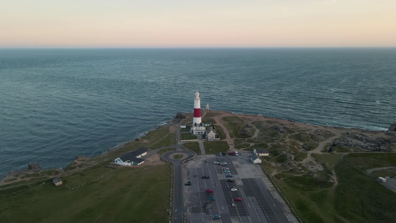 imágenes de 4k de un dron volando lentamente hacia el faro de portland bill, una isla en dorset, inglaterra, y luego lo sobrevuela, durante la puesta de sol
