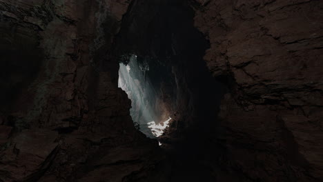 eine schmale öffnung in eine dunkle höhle