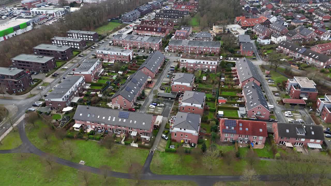 Developing area in american neighborhood. Apartment buildings and single Family homes with solar panels on roof. Cloudy winter day in USA. Aerial top dwn flyover shot.