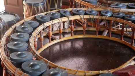 vintage thai style khong wong lek and drums. wooden khong wong lek with gongs and traditional drums placed on wooden floor. thailand music culture objects.