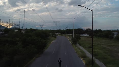 Chico-Yendo-En-Medio-De-Torres-Eléctricas-En-Su-Bicicleta-En-Una-Calle-Solitaria-En-Un-Hermoso-Día