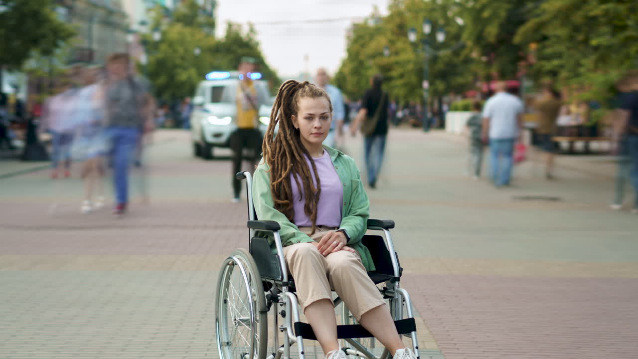 Young woman in a wheelchair in a city park