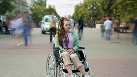 young woman in a wheelchair in a city park