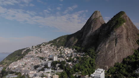 aerial pan showing the two brothers mountain peaks in rio de janeiro with the favela of vidigal on its steep descent