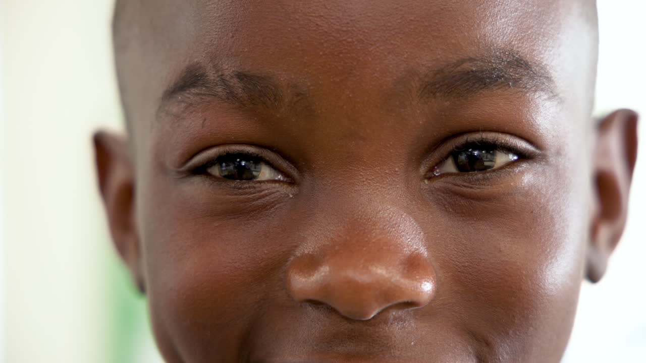 Smiling african american boy showing joy and happiness, close-up of eyes and face, at school